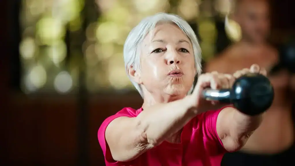 Older woman doing weight training Feltham to help her strength and longevity 